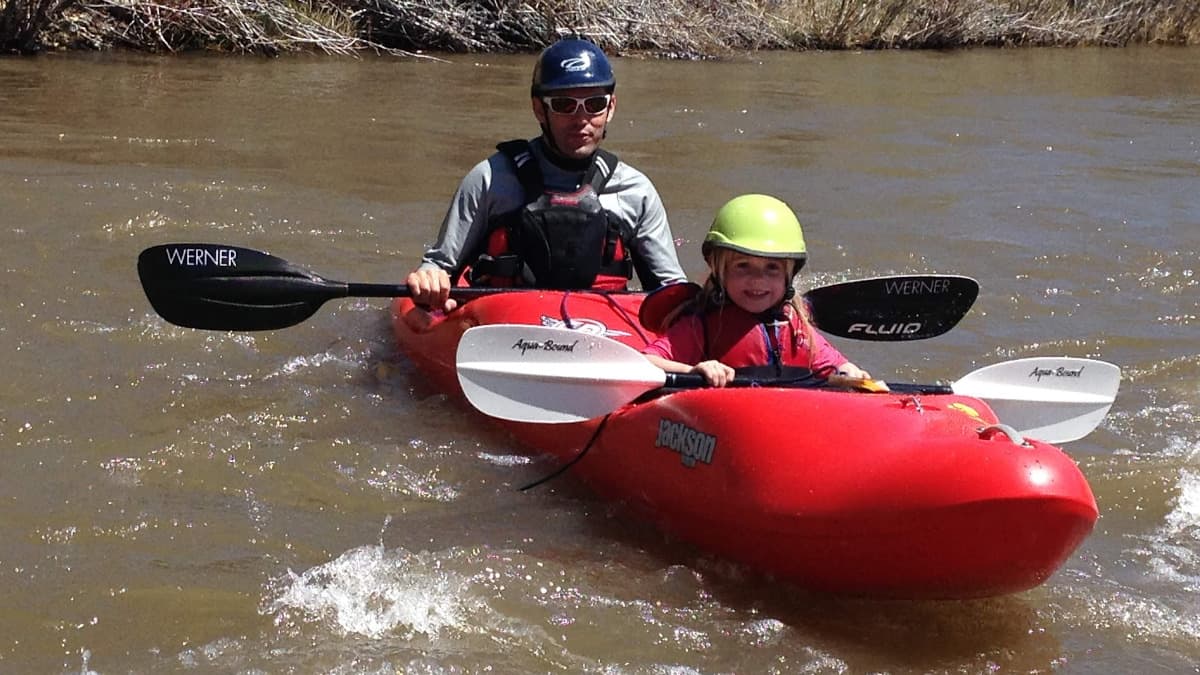 A father and son enjoy a double kayak on the East Fork of the Carson